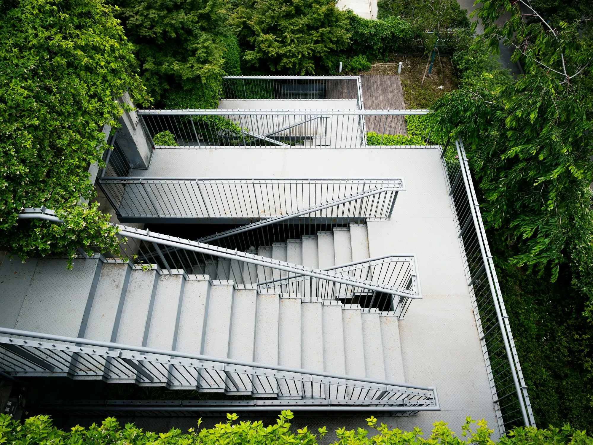 Metalltreppe mit geradlinigen Stahlgeländern in grüner Umgebung